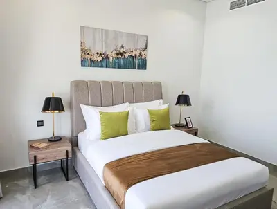 a bedroom with a large bed with two lamps at Southside Spacious & Sleek - 2BR in Dubai