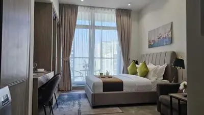 a bedroom with a bed and a large window at Studio Luxe Dubai South in Dubai