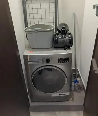 a washing machine with a pot on top of it at The Executive Nest -1BR in Dubai in Dubai
