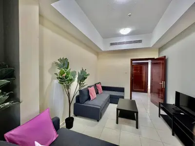a living room with a couch and a tv at Close to The World Trade Center and DIFC in Dubai