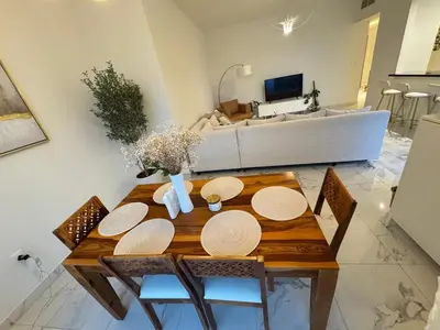 a dining room table with chairs and a couch at Luxury 2BR Canal front & Burj Khalifa views- High Floor in Dubai