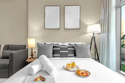 a bedroom with a bed with two plates of fruit on it at Luxury Palm Studio - Skyline Views - Rooftop Pool & Beach Access in Dubai