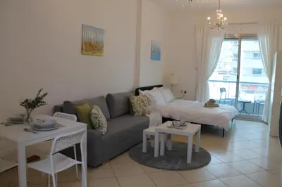 a living room with a couch and a table at Studio apartment walking distance to metro and beach in Marina in Dubai
