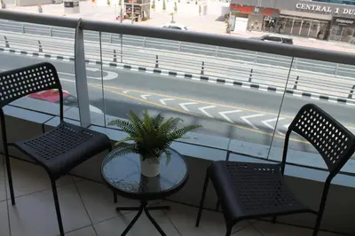 a table and chairs on a balcony with a view of a street at Studio apartment walking distance to metro and beach in Marina in Dubai