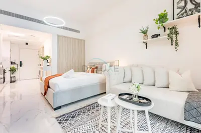 a white living room with a couch and a bed at Just Steps Away from Circle Mall, Right Beside a Park, Near Restaurants, Conveniently Close to a Bus Stop, Lumina Vista Residences, Jumeirah Village Circle by Deluxe Holiday Homes in Dubai