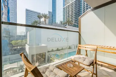 a balcony with chairs and a table on a building at Just Steps Away from Circle Mall, Right Beside a Park, Near Restaurants, Conveniently Close to a Bus Stop, Lumina Vista Residences, Jumeirah Village Circle by Deluxe Holiday Homes in Dubai