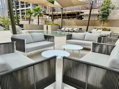 a patio with couches and tables and a pool at DAYF-PENZOR Upgraded Studio for 4 with Full Burj View in Dubai