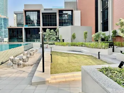 a view of a building with a pool and tables and chairs at DAYF-PENZOR Upgraded Studio for 4 with Full Burj View in Dubai