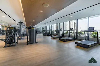 a gym with treadmills and ellipticals in a building at Luxury Studio with Canal View and Jacuzzi by BMS in Dubai