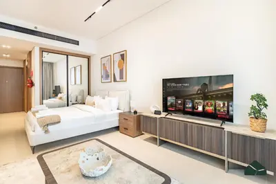 a bedroom with a bed and a flat screen tv at Luxury Studio with Canal View and Jacuzzi by BMS in Dubai