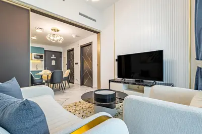 a living room with white furniture and a flat screen tv at Superhost- 1BR Near Miracle Garden, Pool and Gym, Balcony Arjan in Dubai