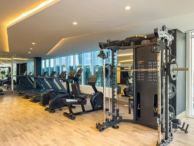 a gym with treadmills and elliptical machines at Superhost- 1BR Near Miracle Garden, Pool and Gym, Balcony Arjan in Dubai