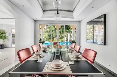 a dining room with a black table and red chairs at DAYF-NIL Lux 5-BR Villa with Pool & Piano - Green Community in Dubai