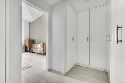 a white room with white cabinets and a hallway at DAYF-NIL Lux 5-BR Villa with Pool & Piano - Green Community in Dubai