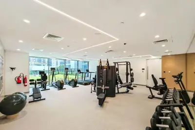 a gym with treadmills and elliptical machines at FAM Living - Elegant 2BR with Park & Creek Panorama in Dubai