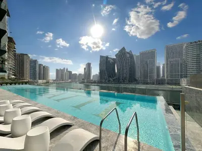 a swimming pool on the roof of a building with tall buildings at Skyline Views Chic 1BR with Canal Vibes in Dubai