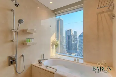 a bathroom with a bath tub and a large window at The Serene in Dubai