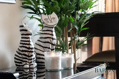two statues of cats sitting on a table with candles at The Serene in Dubai