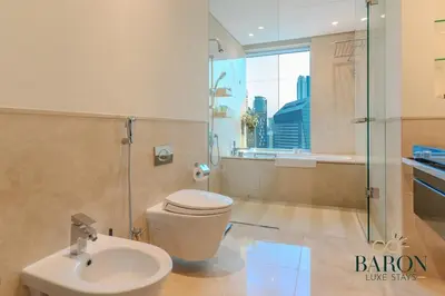 a bathroom with a toilet and a shower and a sink at The Serene in Dubai