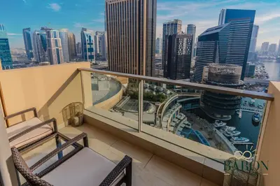 a balcony with two chairs and a view of a city at The Serene in Dubai