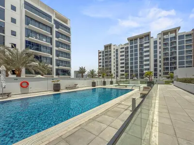 a swimming pool with buildings in the background at Elite Escape - Boho Getaway in Azizi Riviera 16 in Dubai