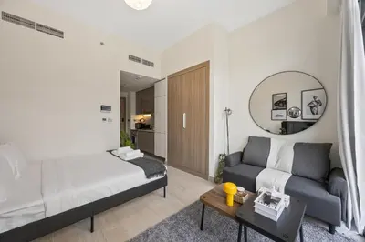 a bedroom with a bed and a couch and a mirror at Elite Escape - Boho Getaway in Azizi Riviera 16 in Dubai