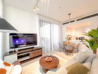 a living room with a couch and a tv and a table at 2 Bed, Private Pool, Big Terrace, Solysian Stay in Dubai