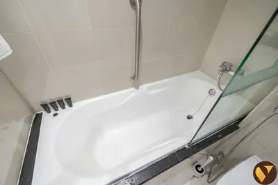 a white bath tub with a shower in a bathroom at Vogue Business Bay Damac Cour Jardin close to Downtown, Burj Khalifa and Dubai Mall, Studio Apartment with City View, Access to all Amenities in Dubai