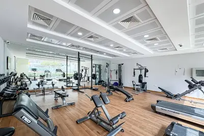 a gym with a lot of treadmills and exercise bikes at Bright and Stylish 2 Bed Home Opposite Circle Mall in Dubai