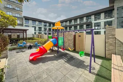a playground in front of a building at Bright and Stylish 2 Bed Home Opposite Circle Mall in Dubai