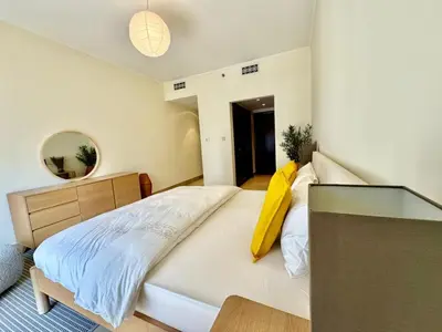a bedroom with a bed with a yellow pillow on it at Only family Walking distance to Dubai Mall in Dubai
