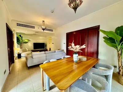 a living room with a wooden table and chairs at Only family Walking distance to Dubai Mall in Dubai