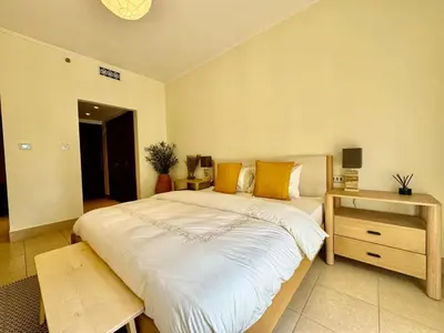 a bedroom with a large bed and a wooden table at Only family Walking distance to Dubai Mall in Dubai