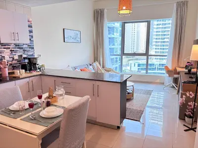 a kitchen and dining room with a table and chairs at Premium 1BR in Dubai Marina King Bed, Marina View, Near JBR, Beach & Vibrant Nightlife in Dubai