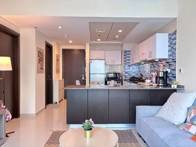 a living room with a couch and a kitchen at Premium 1BR in Dubai Marina King Bed, Marina View, Near JBR, Beach & Vibrant Nightlife in Dubai