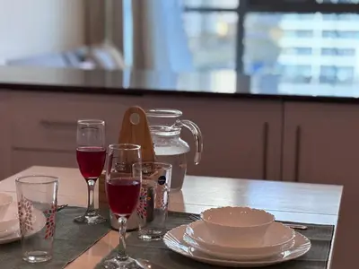 a table with two glasses of wine and a plate at Premium 1BR in Dubai Marina King Bed, Marina View, Near JBR, Beach & Vibrant Nightlife in Dubai