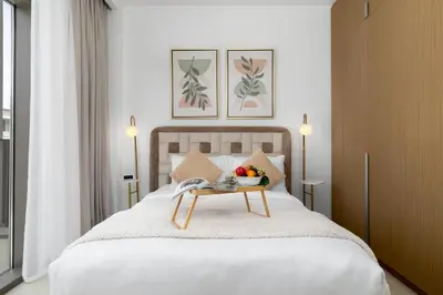 a bed with a table with a bowl of fruit on it at Maison Privee - Charming Urban Escape with Resort-Style Facilities in Dubai