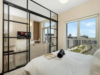 a bedroom with a white bed and a large window at Stylish 1BR in Socio Pool, Cinema & Game Lounge in Dubai