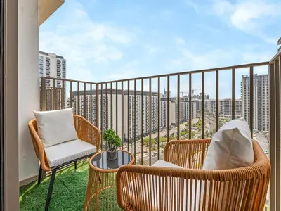 a balcony with two wicker chairs and a table at Stylish 1BR in Socio Pool, Cinema & Game Lounge in Dubai