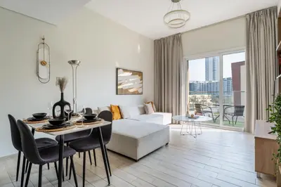 a living room with a white couch and a table at GuestReady – Relax Stay w Balcony & Pool View in Dubai