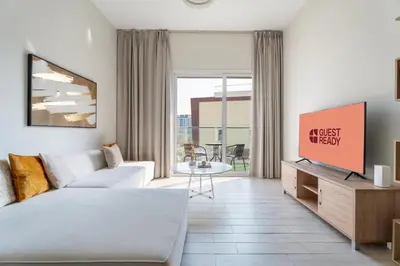 a living room with a couch and a tv at GuestReady – Relax Stay w Balcony & Pool View in Dubai
