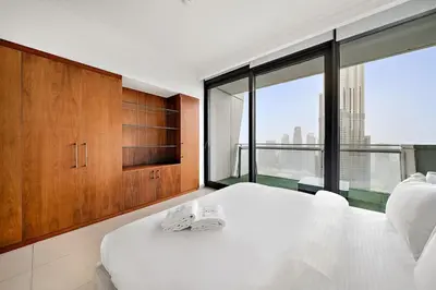 a bedroom with a white bed and a large window at FIRST CLASS 3BR Stunning Burj Khalifa View in Dubai