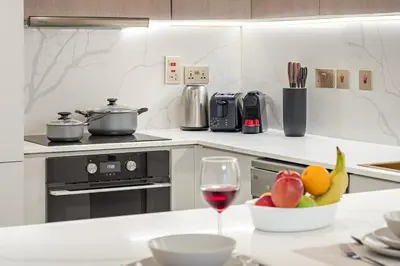 a kitchen with a glass of wine and a bowl of fruit at FIRST CLASS1BR Sea View and Near Beach and Tram in Dubai