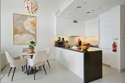 a kitchen with white cabinets and a table and chairs at DAYF-JFH Spacious Apartment 4 PAX with Magical Lagoon Views in Dubai