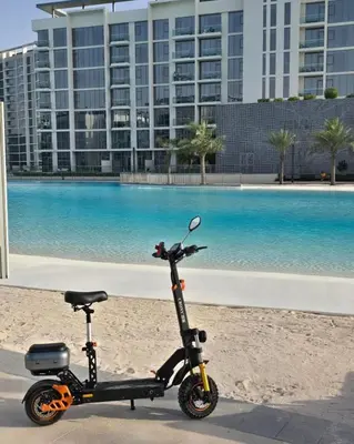 a scooter parked on the beach in front of a building at DAYF-JFH Spacious Apartment 4 PAX with Magical Lagoon Views in Dubai