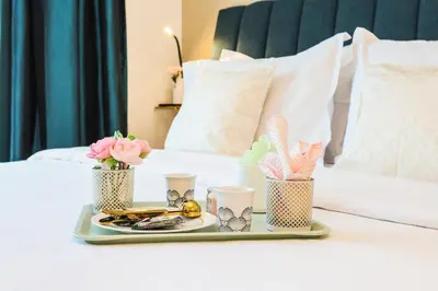 a tray with a tray of food and flowers on a bed at FIRST CLASS Studio Cozy Vibes and Stylish Escape in Dubai