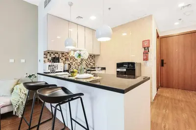 a kitchen with a counter and stools in a room at FIRST CLASS Studio Cozy Vibes and Stylish Escape in Dubai