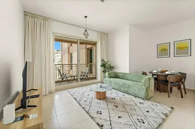 a living room with a green couch and a table at FIRST CLASS 1BR Modern Urban Retreat in Dubai