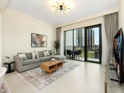 a living room with a couch and a tv at Island Park Comfort Stay in Dubai