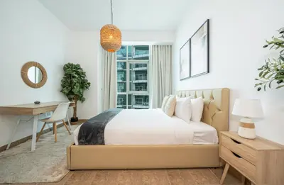 a bedroom with a bed and a desk and a desk at Luxury 1BR with Pool, Gym Canal & Burj Khalifa view in Dubai